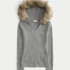 Kabelstrikket sweater med hætte og kant af imiteret pels Kabelstrikket sweater med hætte og kant af imiteret pels
