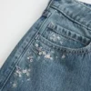 Lavtaljede, mørkvaskede baggy jeans med blomsterbroderi Lavtaljede, mørkvaskede baggy jeans med blomsterbroderi