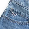 Lavtaljet denim miniskort med broderet sløjfe Lavtaljet denim miniskort med broderet sløjfe