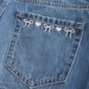 Lavtaljet denim miniskort med broderet sløjfe Lavtaljet denim miniskort med broderet sløjfe
