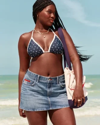 Lavtaljet mini-skort i mediumvasket denim med broderet flag
