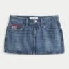 Lavtaljet mini-skort i mediumvasket denim med broderet flag Lavtaljet mini-skort i mediumvasket denim med broderet flag