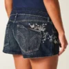 Ultra lavtaljede mørkvaskede mini-shorts i denim med broderet sommerfugl Ultra lavtaljede mørkvaskede mini-shorts i denim med broderet sommerfugl