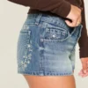 Ultra lavtaljet mini-shorts i mediumvasket denim med blomsterbroderi Ultra lavtaljet mini-shorts i mediumvasket denim med blomsterbroderi