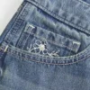Ultra lavtaljet mini-shorts i mediumvasket denim med blomsterbroderi Ultra lavtaljet mini-shorts i mediumvasket denim med blomsterbroderi
